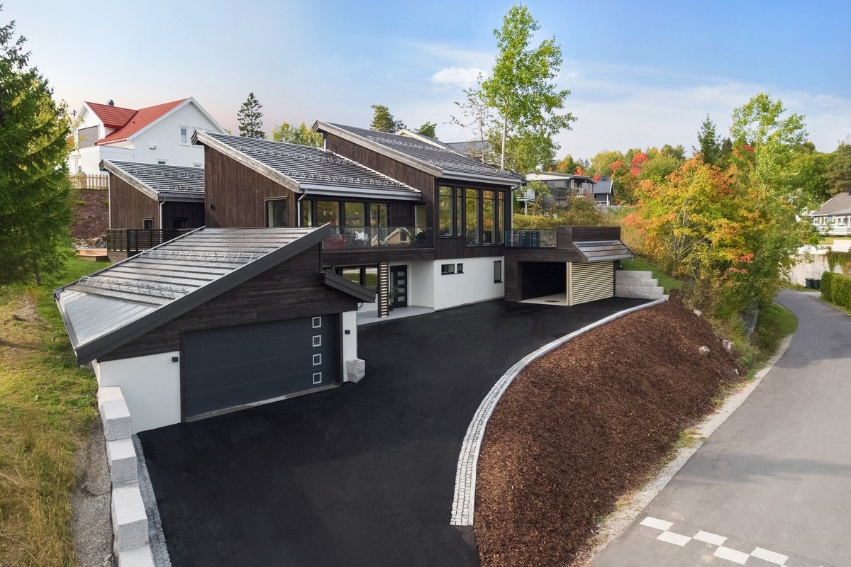Det er parkering i carport og i dobbelgarasje med leddport av stål med portåpner. Galleribilde