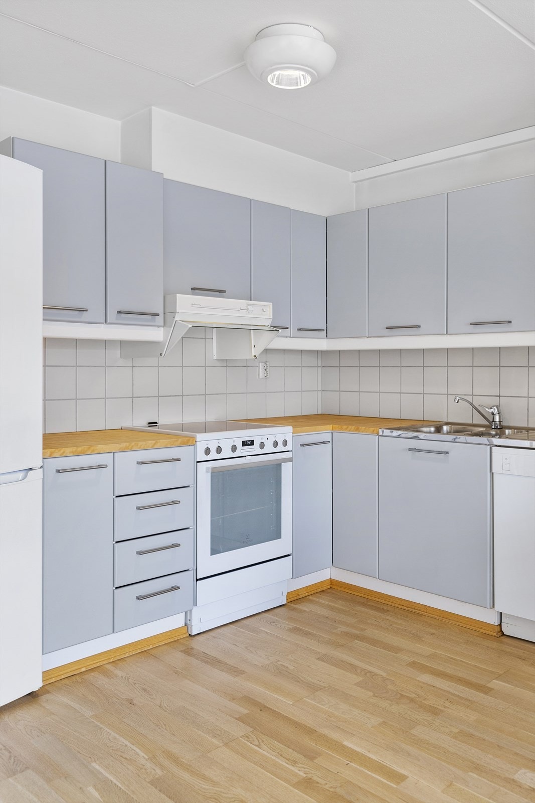 Kjøkkeninnredning med glatte malte fronter, laminat benkeplate samt heldekkende rustfri kum. Galleribilde