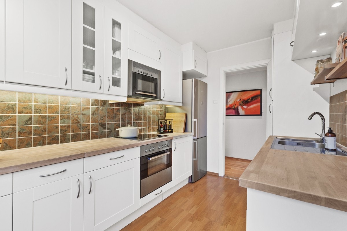 Kjøkkeninnredningen er fra IKEA og har profilerte fronter og benkeplate i tre. Benkeplaten er nylig slipt og oljet. Galleribilde