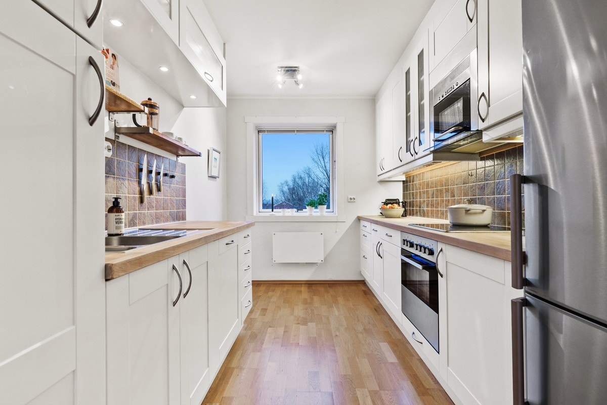 Separat kjøkken med god skap- og benkeplass, samt koselig plass ved vindu for frokostbord. Galleribilde