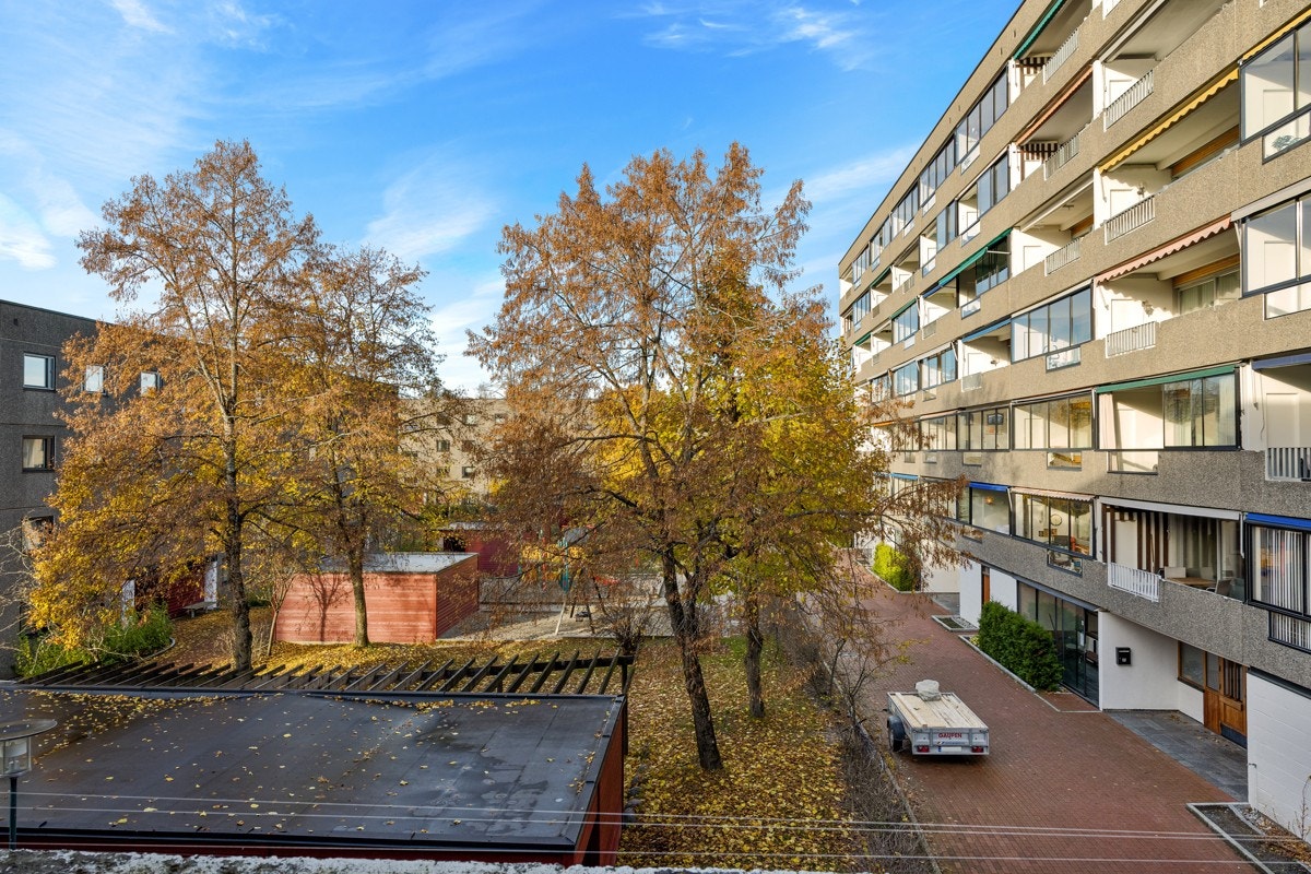 Leiligheten vender ut mot et hyggelig tun med trær og beplantning Galleribilde