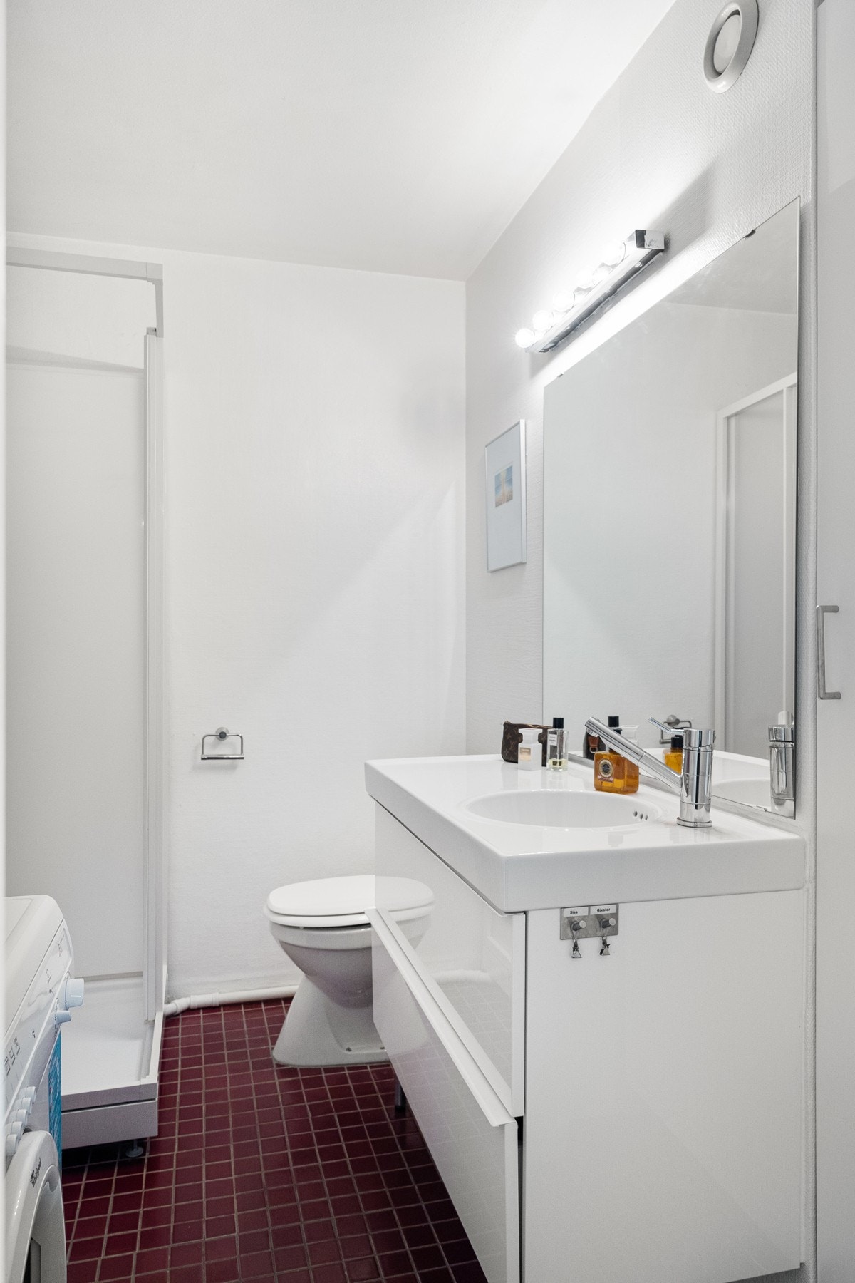 Badet har pen servant i skuffeinnredning og stort speil med god belysning Galleribilde