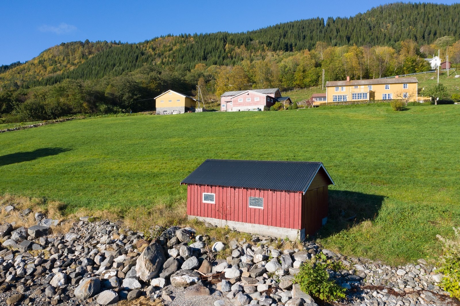 Tomt på 87,5 dekar fordelt på overside og nedside av hovedvei. Galleribilde