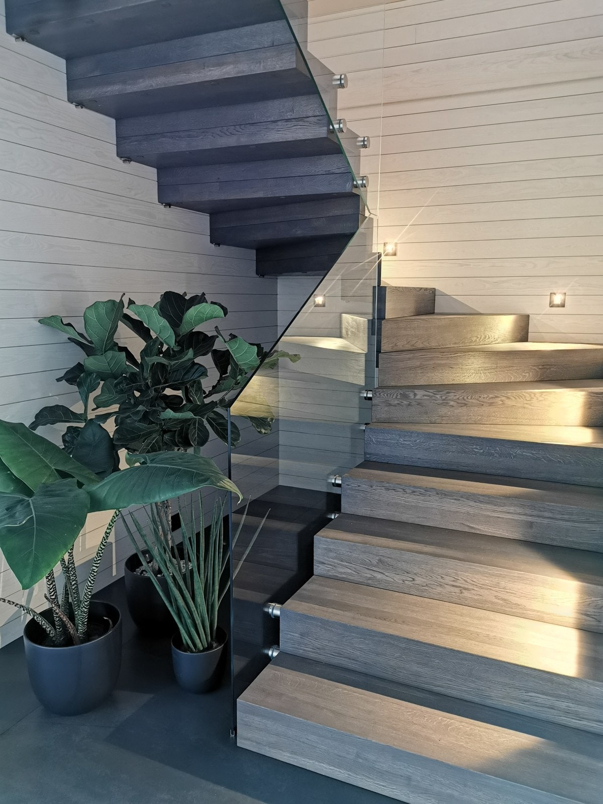 Trapp som er håndlaget i heltre eik med glass rekkverk og innfelt trappebelysning. Galleribilde