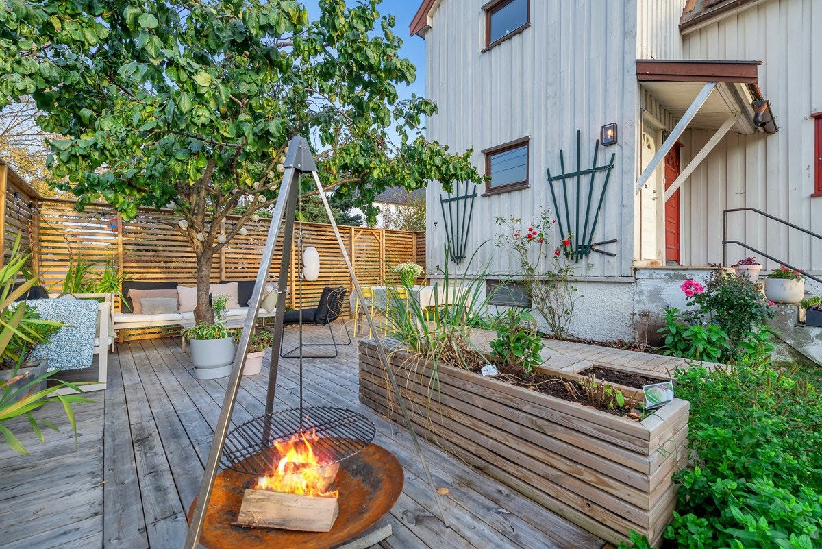 Det er bygget blomsterkasse, rammet inn bed og åpnet opp for et tre som skaper ekstra liv til uteplassen. Galleribilde