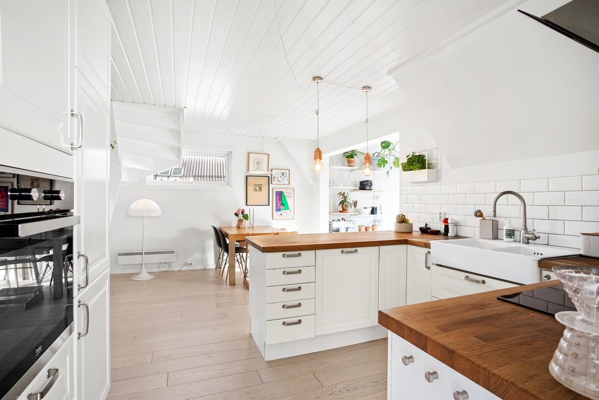 Kjøkkenet ligger åpent til stuen og har en kledelig, hvit innredning fra 2011, med klassiske profilfronter. Innredningen består av benkeskap i u-form, som ender i barløsning, og en teknisk vegg Galleribilde