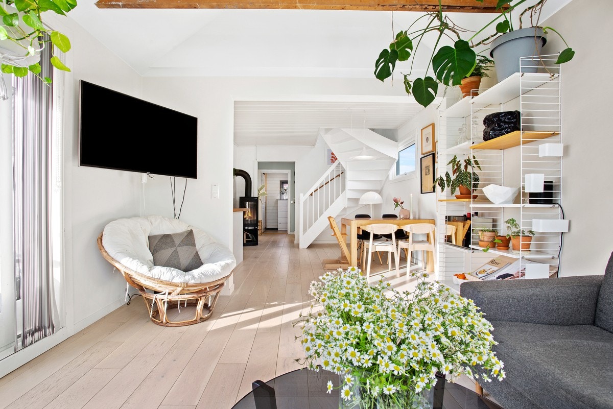 Den innerste delen av rommet brukes som sofasone, og det er spiseplass og peisovn i området nærmest kjøkkenet. Galleribilde