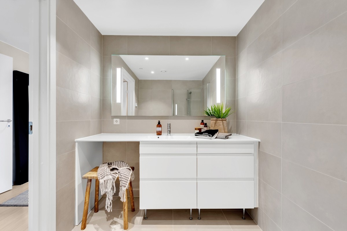 Delikat hovedbad sandfargede fliser, gulvvarme og downlights. Galleribilde