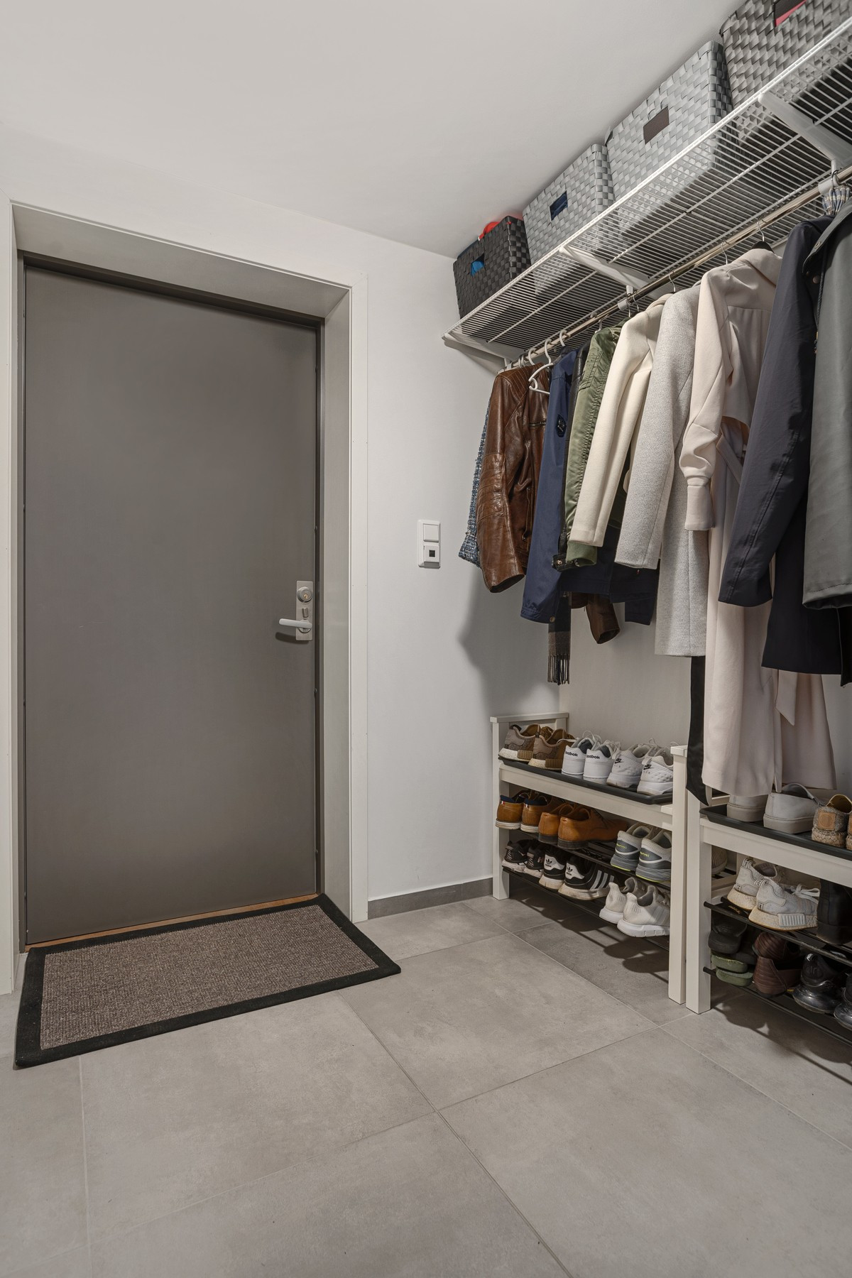 Gang med fliselagt gulv og gode oppbevaringsmuligheter