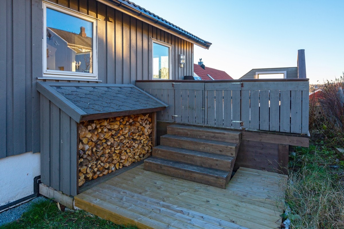 Fra verandaen er det port og trapp ned til et praktisk vedskjul. Galleribilde