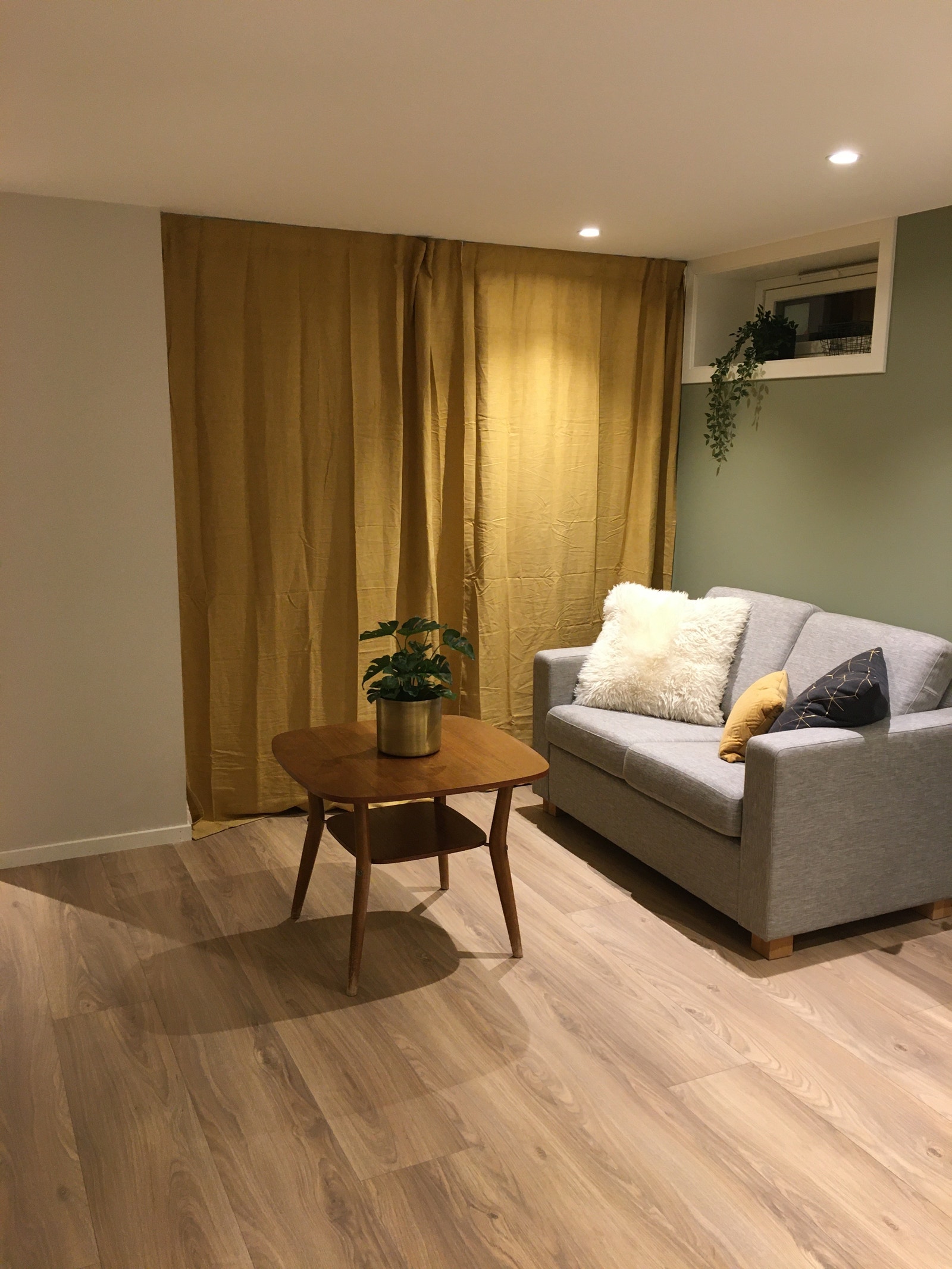 Delvis møblert med sofa og bord. Forheng inn til sovealkove Galleribilde