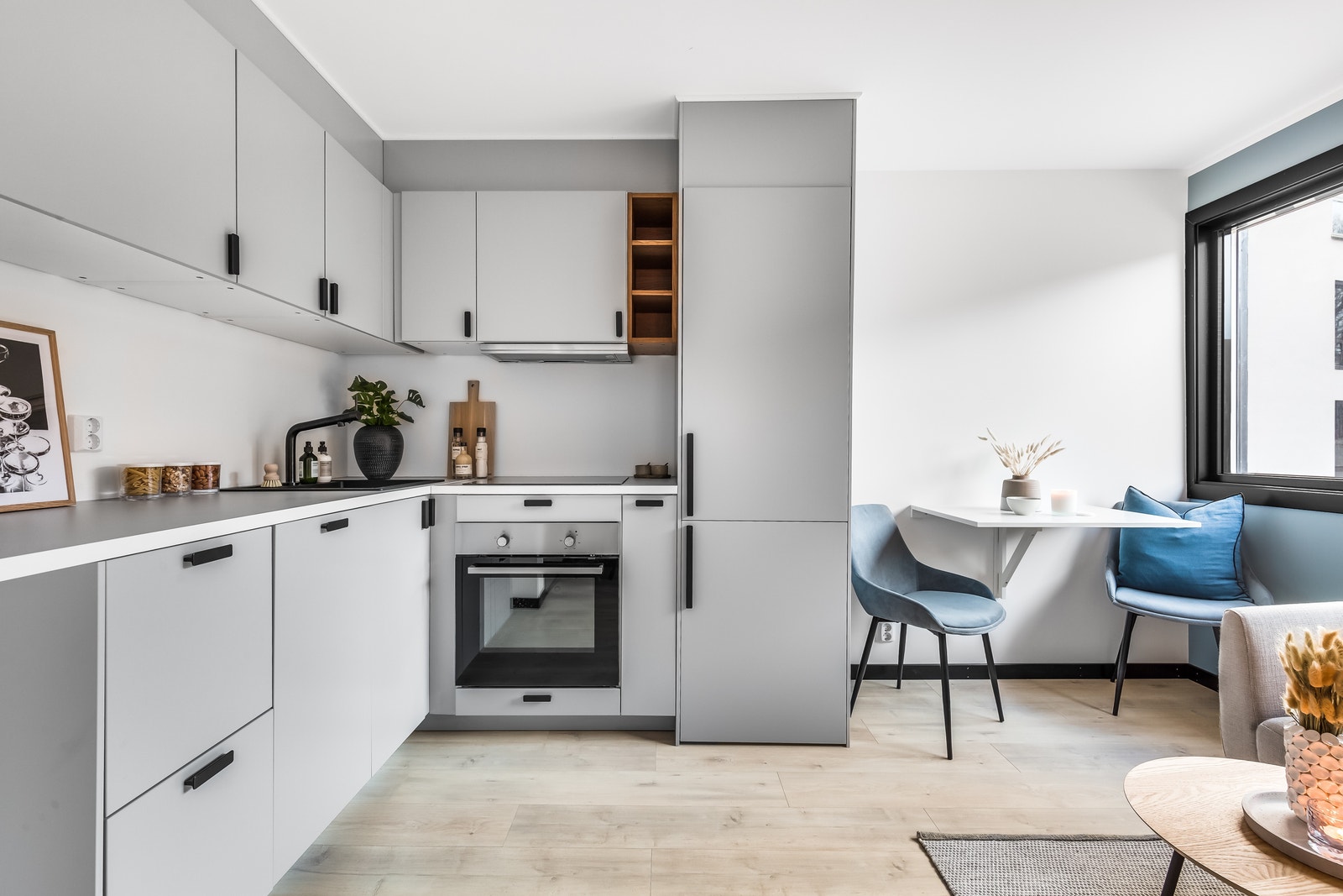 Stuen har åpen kjøkkenløsning - moderne kjøkken - plass til lite spisebord Galleribilde