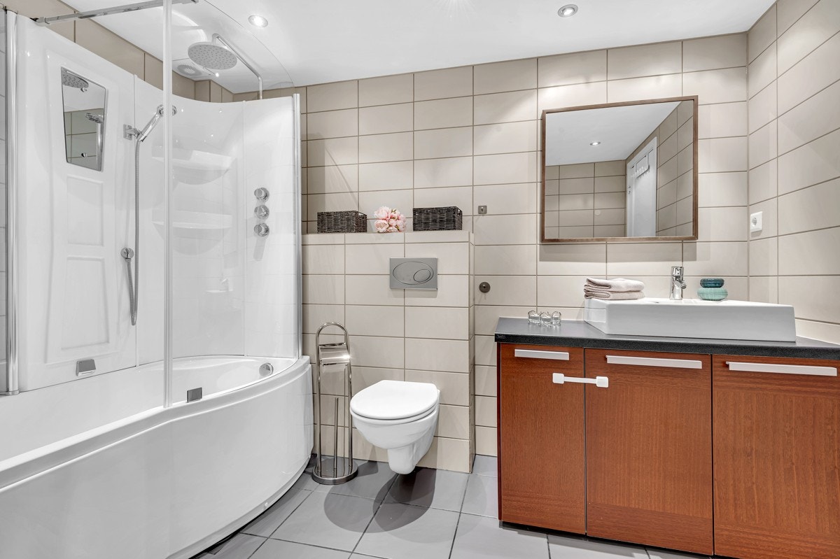 Romslig og pent flislagt bad beliggende i boligens underetasje Galleribilde