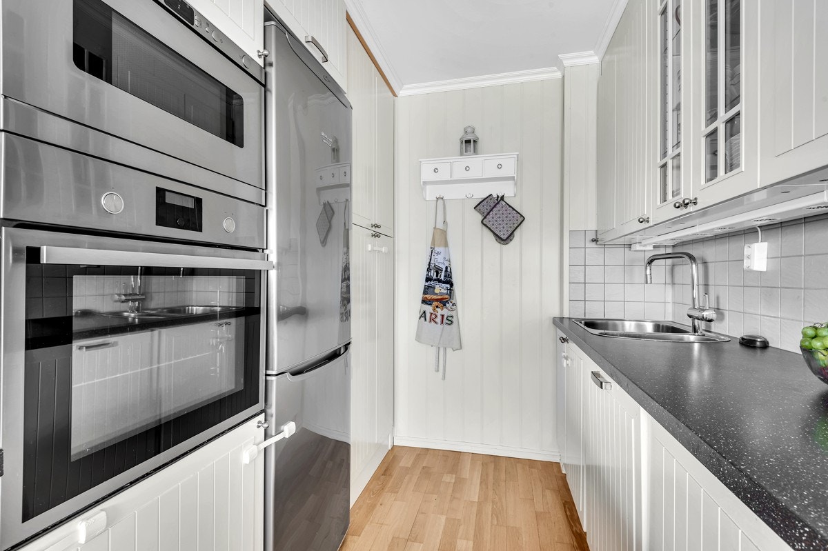 Kjøkkenet leveres med integrerte hvitevarer som platetopp, komfyr, micro og oppvaskmaskin Galleribilde