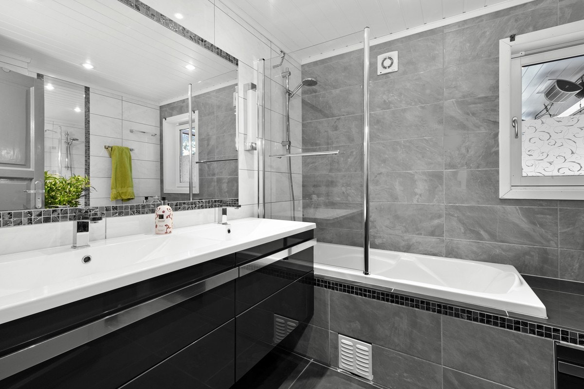 Badet i første etasje gir et pent inntrykk med flislagte overflater, gulvvarme, mekanisk avtrekk og downlights. Galleribilde