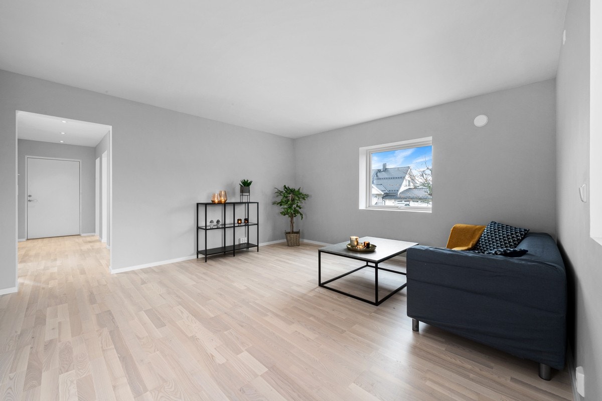 Stuen har gråmalte og slette vegger. Galleribilde