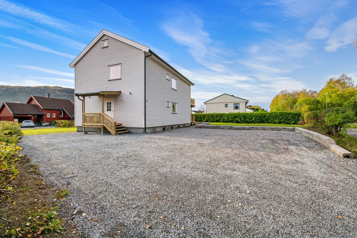 Det er parkering på en stor, gruslagt gårdsplass. Galleribilde