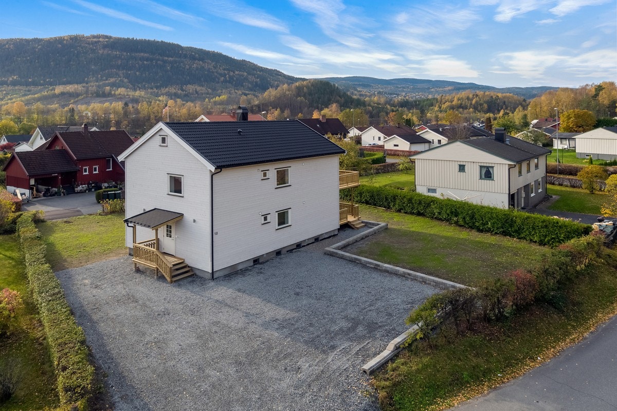 Det er parkering på en stor, gruslagt gårdsplass. Galleribilde