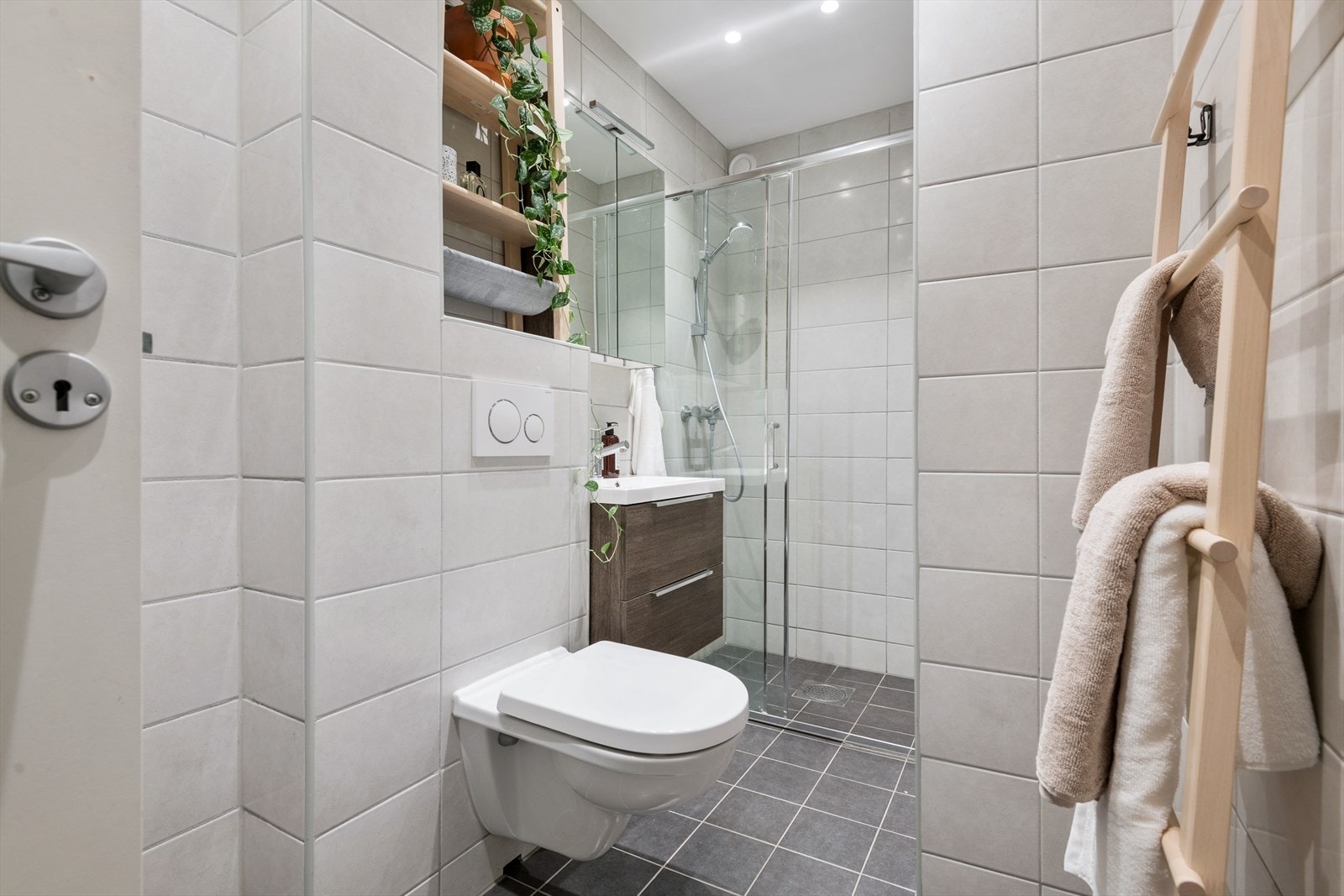 På badet er det vegghengt toalett og et dusjhjørne med skyvedør. Galleribilde