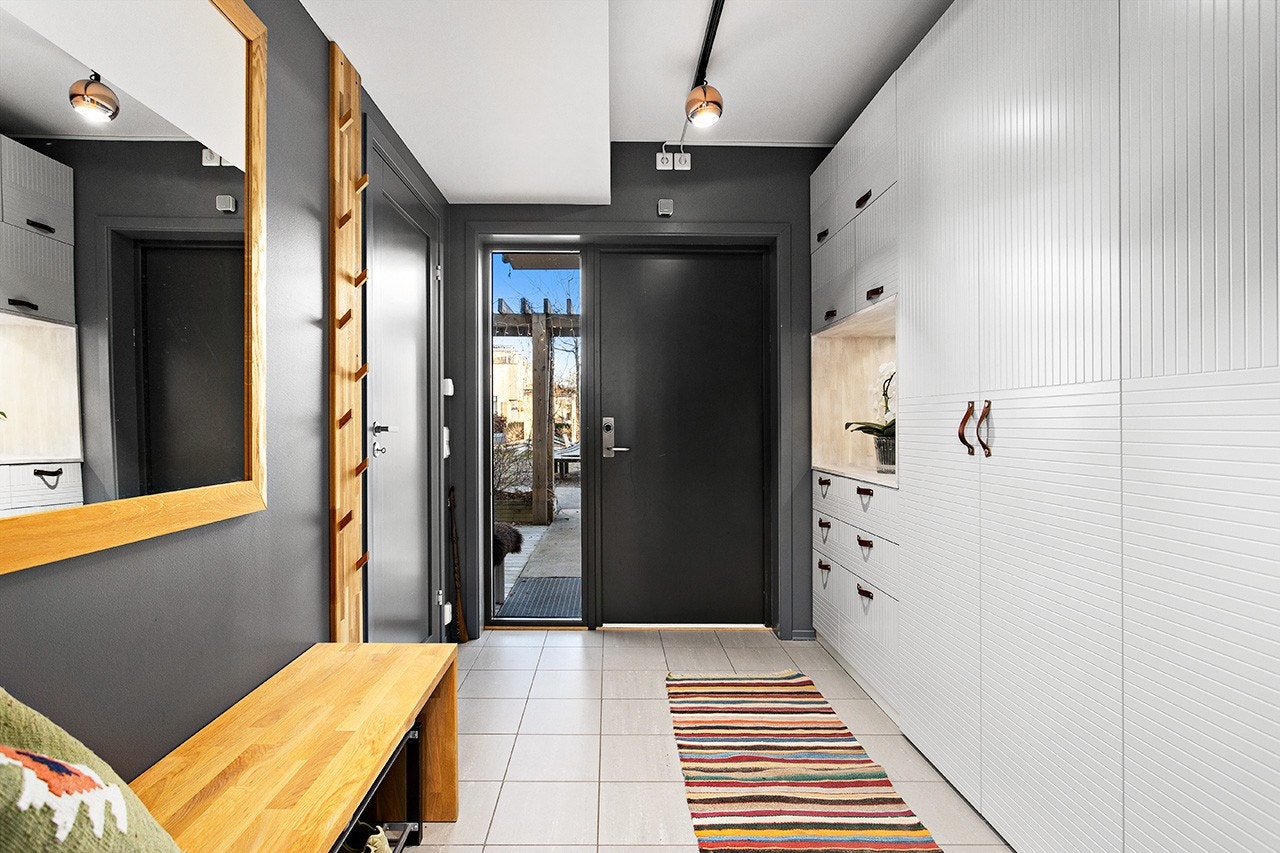 Den innbydende og romslige entréen gir et godt førsteinntrykk. Her er det innbygget garderobeløsning. Døren inn til boden ses til venstre. Galleribilde