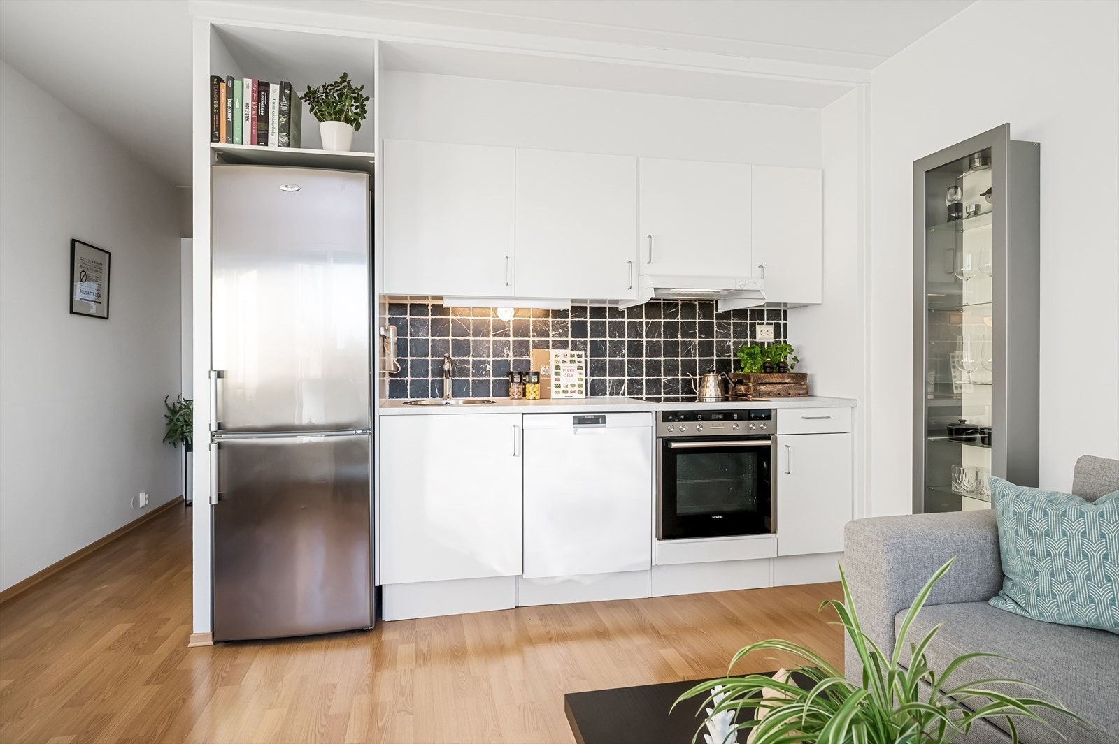 Kjøkkenet har en tidløs HTH-innredning med hvite, glatte fronter og rustfri oppvaskkum. Galleribilde