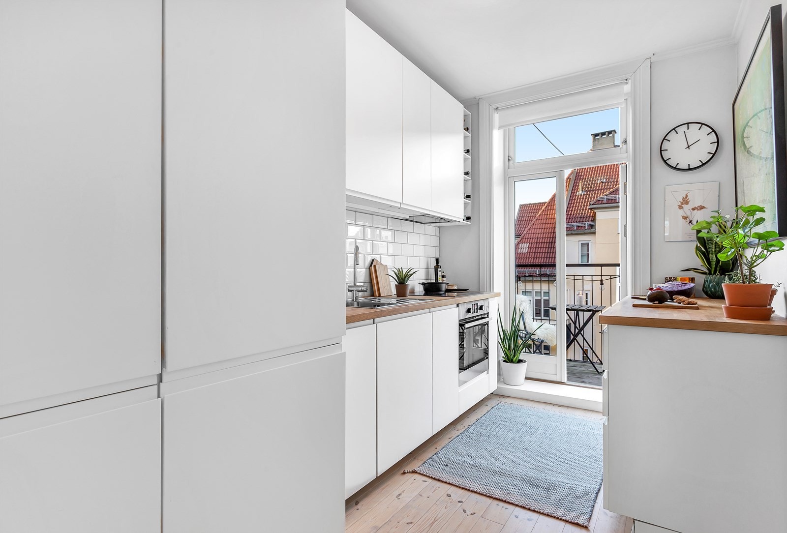 Eget kjøkkenrom med tilgang til vestvendt balkong. Ikea-innredningen ble montert i 2015 og har hvite slette fronter og heltre benkeplater. Galleribilde
