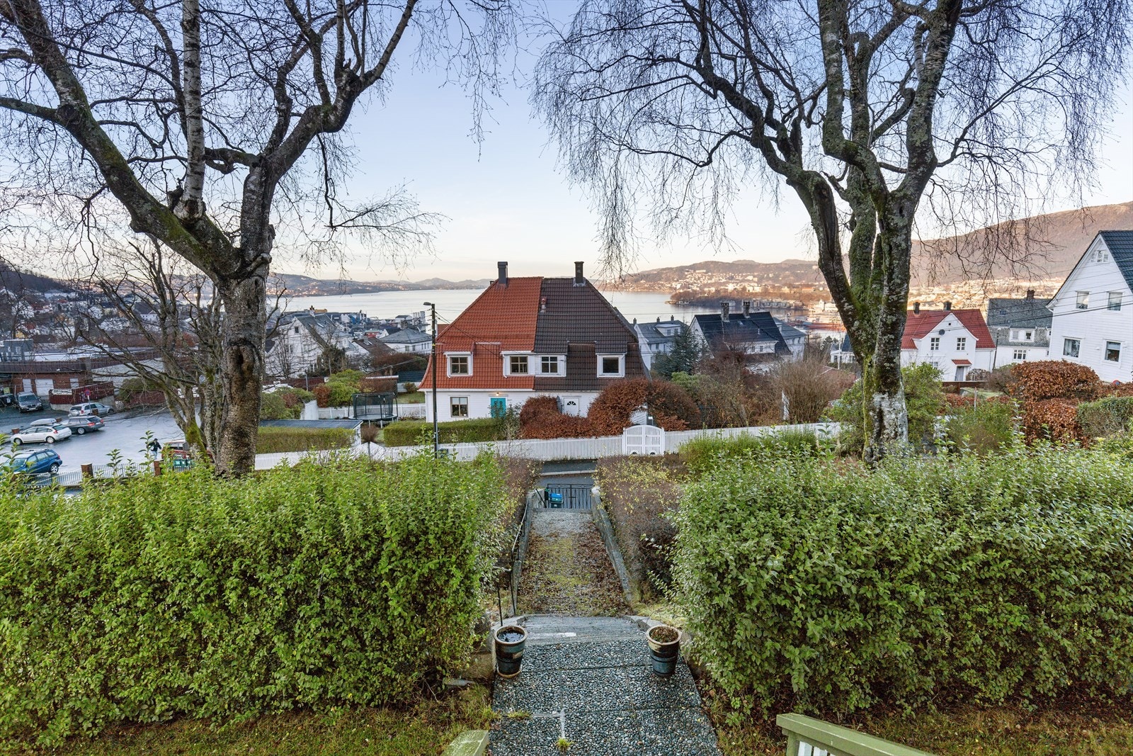 Støpt trapp med skifer i trinn til grusete gangveier med plen/div. beplantninger og prydbusker Galleribilde