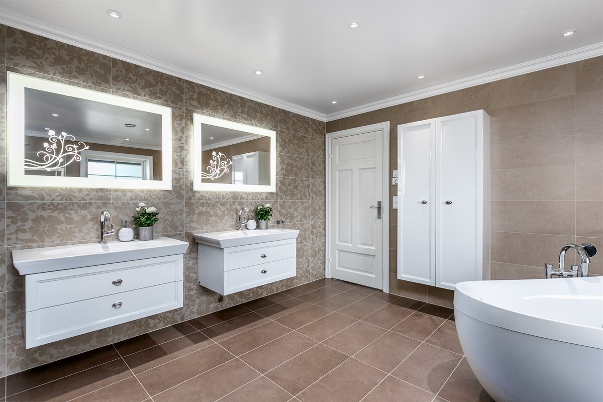 Videre har badet massasjebadekar med blandebatteri fra Villeroy& Bosch, dusjhjørne med svingbare dører og dusjarmatur fra Hansgrohe av typen Rainshower, bidé og vegghengt toalett av typen Villeroy & Bosch Subway. Galleribilde