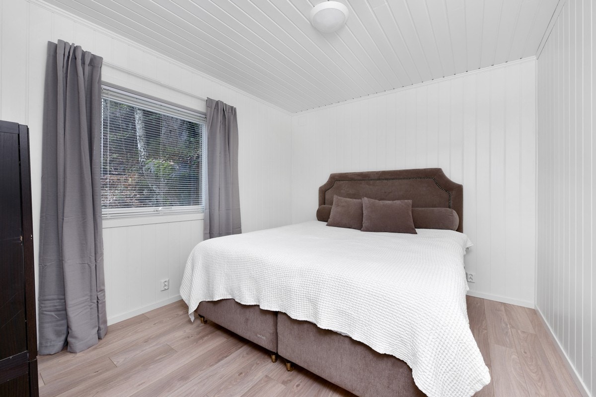 Leiligheten har to soverom, som begge er pusset opp med lyse panelvegger og laminatgulv. Her fra hovedsoverommet. Galleribilde