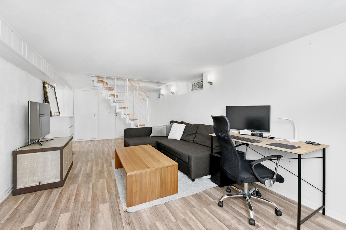 Stuen i underetasjen har hvitmalte vegger og lyst laminatgulv. Galleribilde