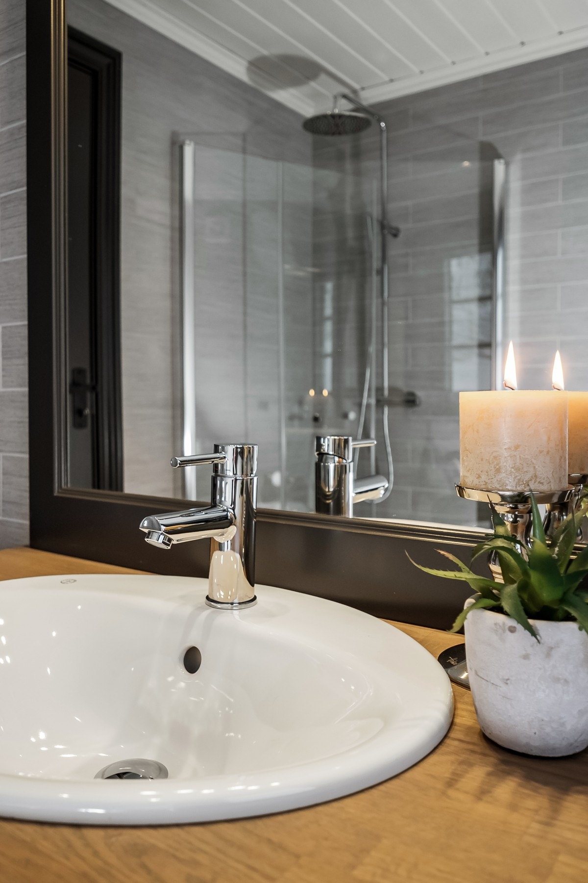 Badet er innredet med toalett, dusjhjørne med innfellbare glassdører og servant med innredning under. Galleribilde