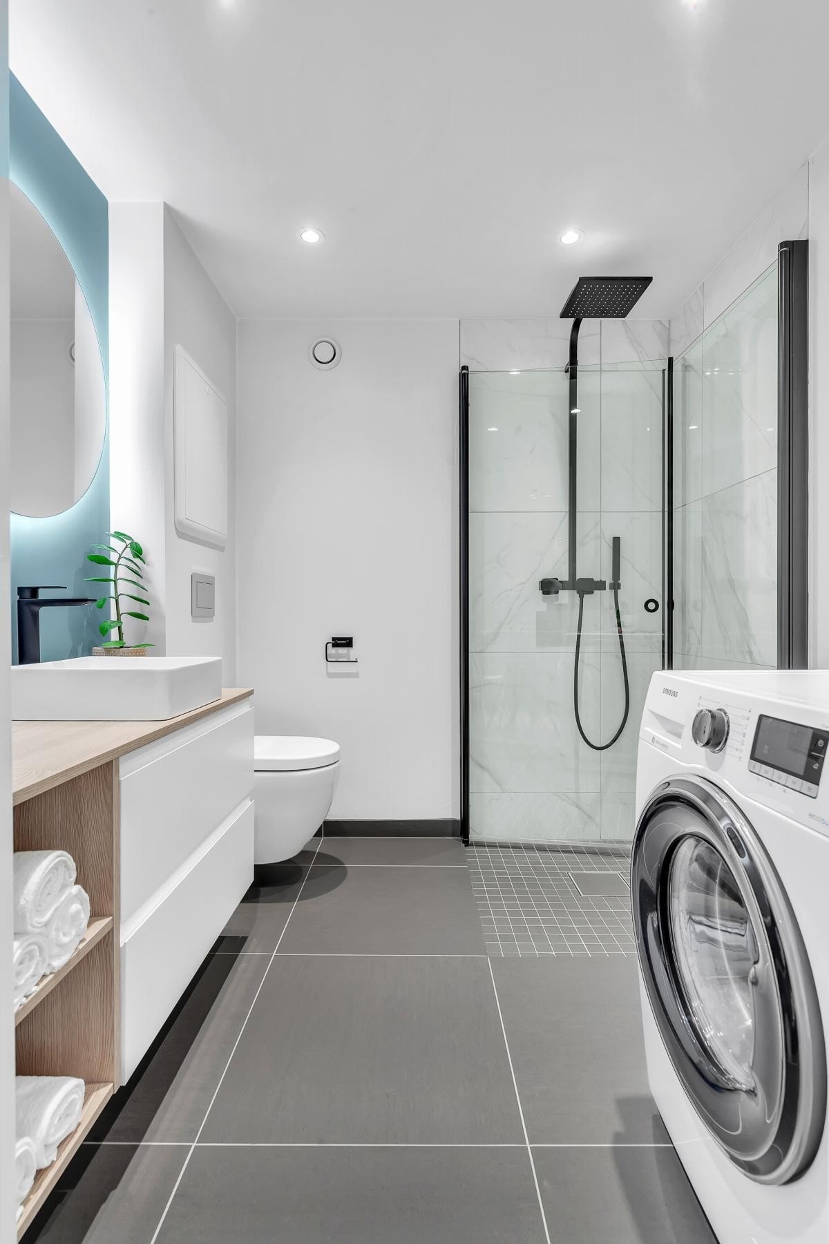 På gulvet er det store, grå fliser med gulvvarme, og himling er lyssatt med led-downlights Galleribilde