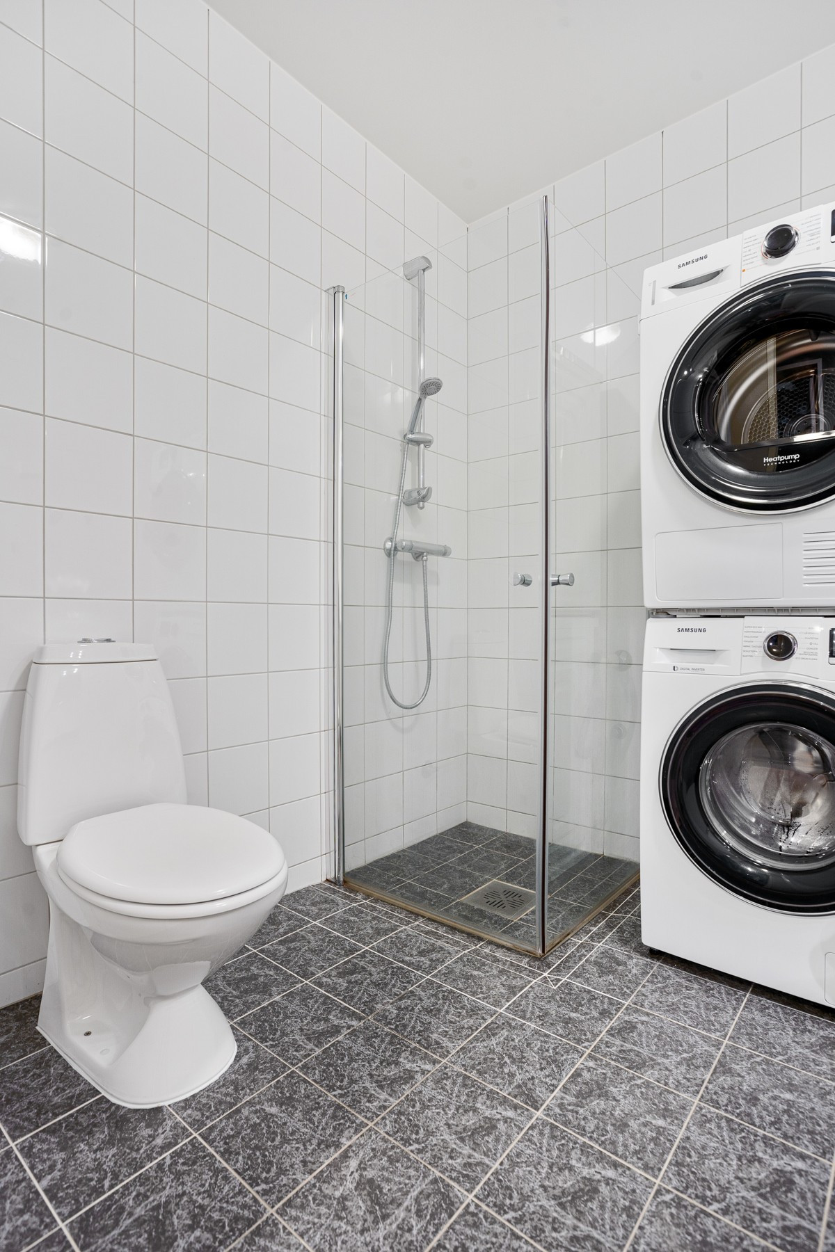 Badet er innredet med dusjhjørne, servant og toalett - det er også opplegg for vaskemaskin
