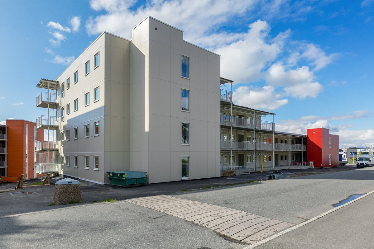 Fasade sett fra baksiden av leilighetskomplekset. Kort vei til dagligvarebutikk og bussholdeplass