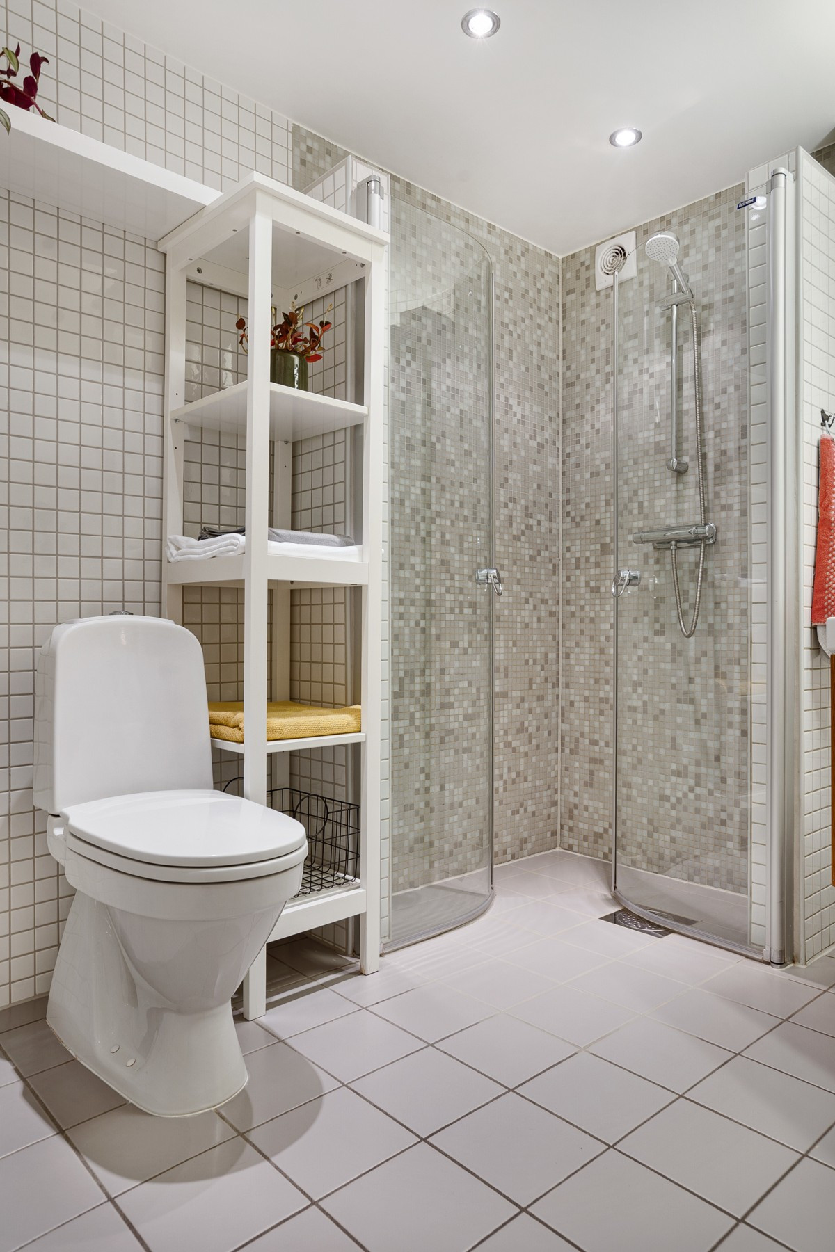 Badet fremstår moderne med downlights i himling og stilige flisekombinasjoner.