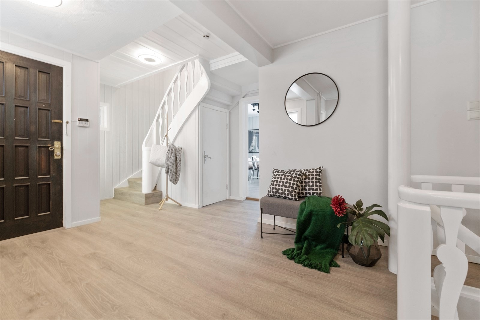 Her ønskes du velkommen av en romslig entré/hall med enstavs laminatgulv, lysmalte panelvegger og god plass for kommoder, skap og lignende. Galleribilde