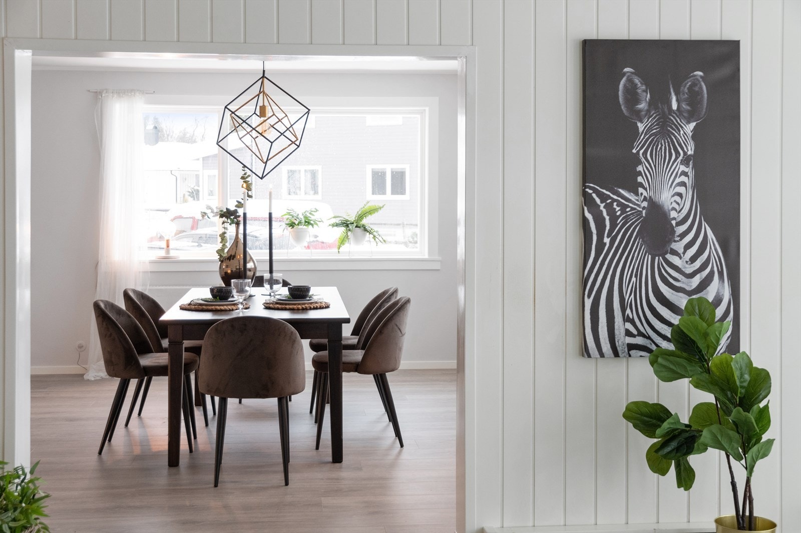 Stuene i første etasje ligger i flukt, med åpning mellom hvert rom, og har enstavs laminatgulv og lysmalte vegger Galleribilde