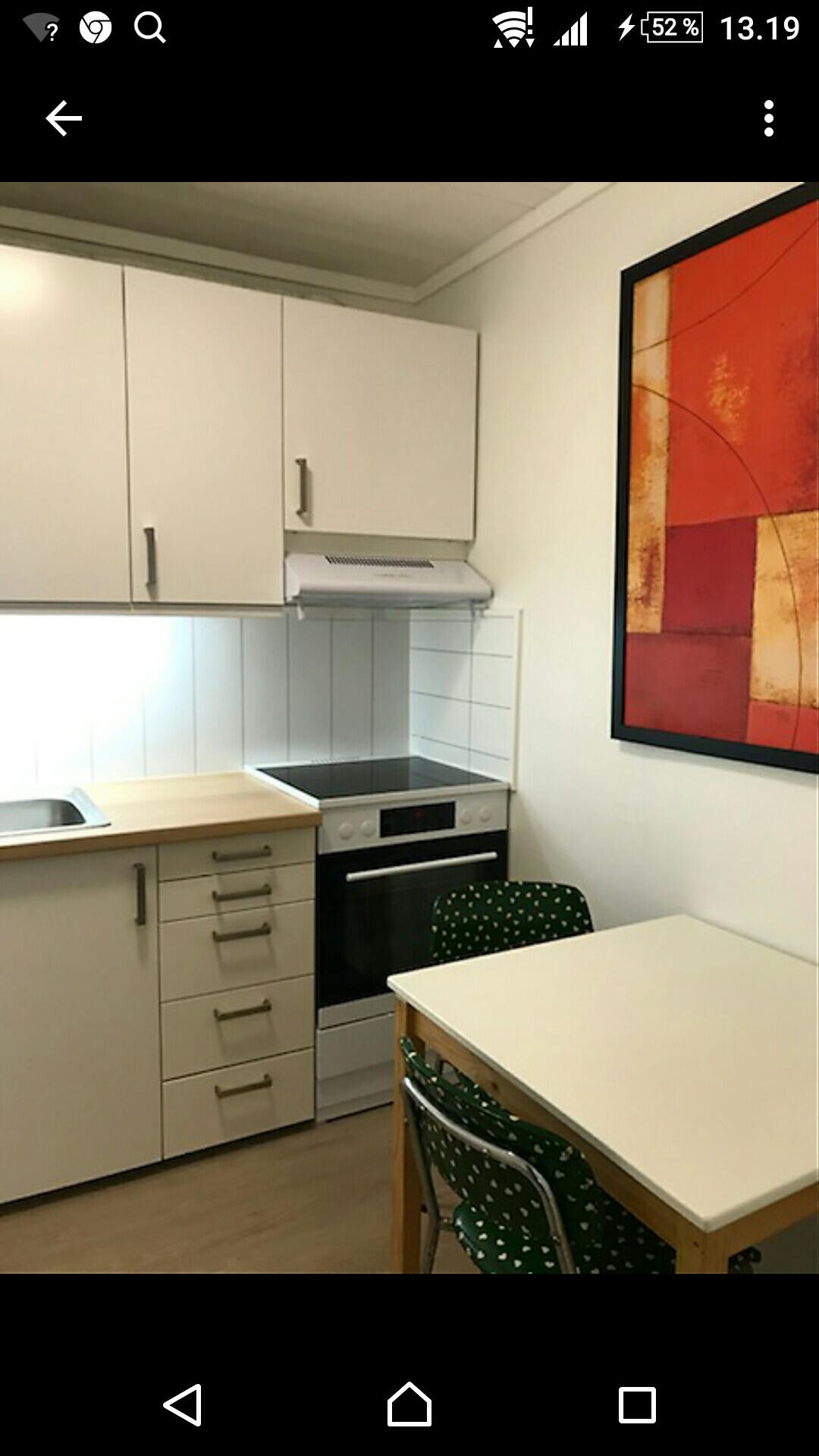 Kjøkkenet med bord, stoler og hvitevarer Galleribilde