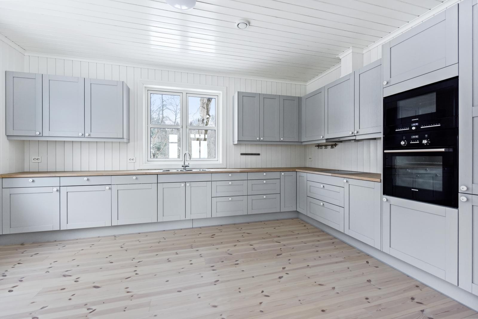 Kjøkken med integrerte hvitevarer, heltre benkeplate og nedfelt kum Galleribilde