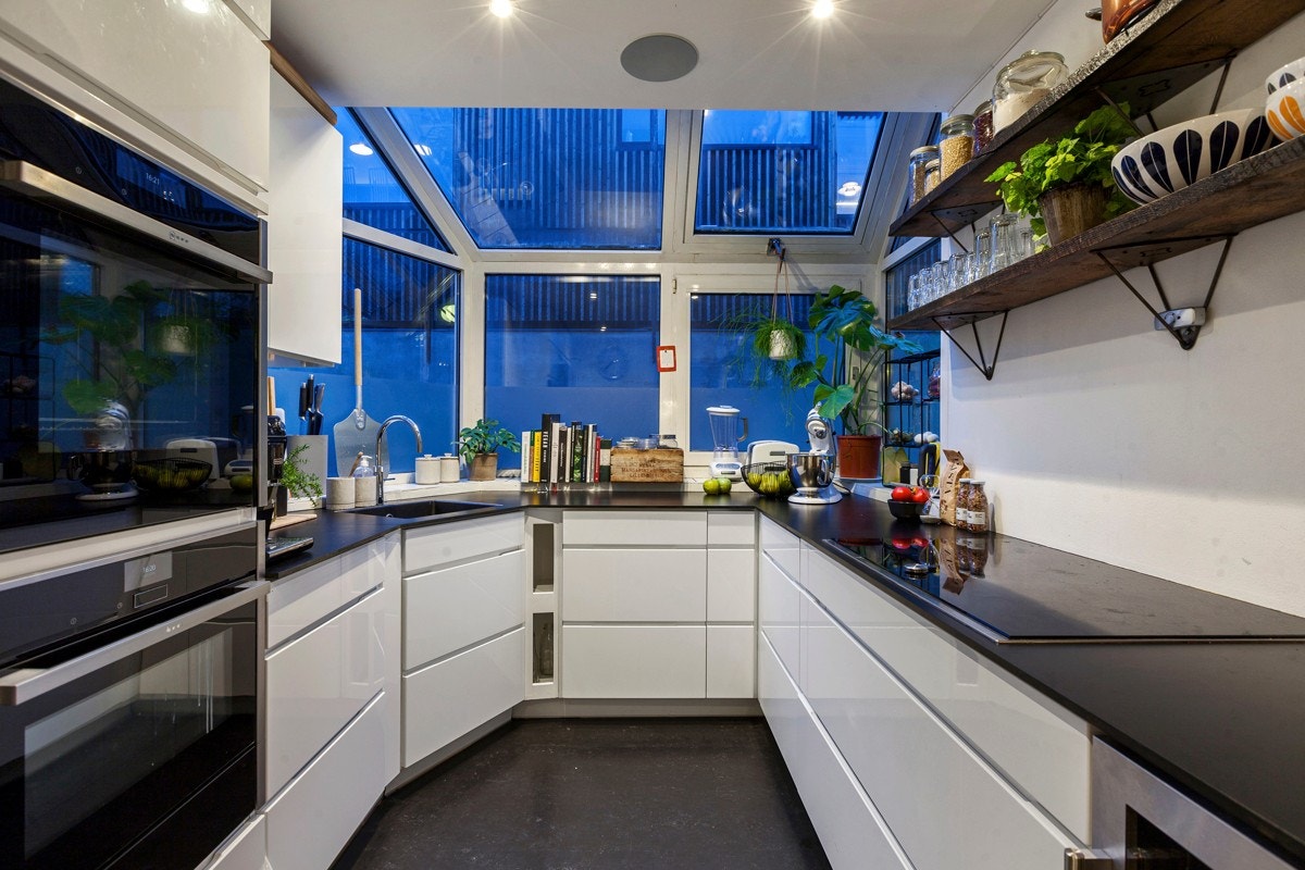 Kjøkkenet ligger i eget rom og har innredning fra Kvik (2015) med glatte fronter i hvit høyglans Galleribilde