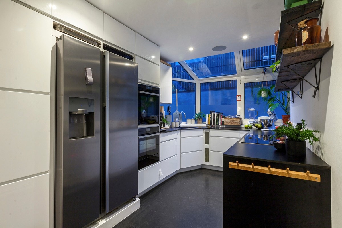 Kjøkkenet ligger delvis i et påbygg fra 1986 med moderne utseende hvor det er vinduer i hele fronten på kjøkkenet Galleribilde