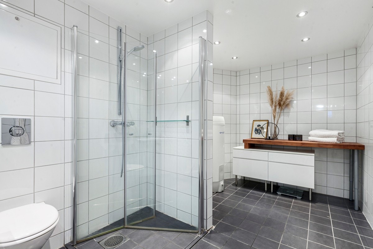 Badet i underetasjen har flislagte overflater og downlights Galleribilde