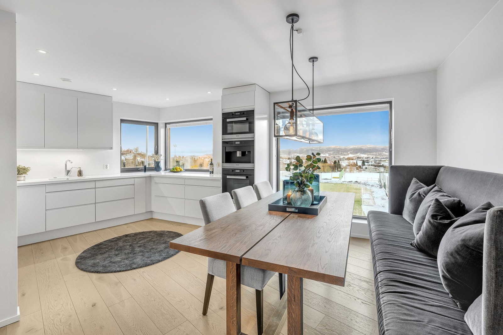 Stort kjøkken fra Sigdal med Corian benkeplate. Kjøkkenet har integrert platetopp, stekeovn, mikrobølgeovn, oppvaskmaskin, kjøl/fryseskap og kaffemaskin fra Miele. Galleribilde