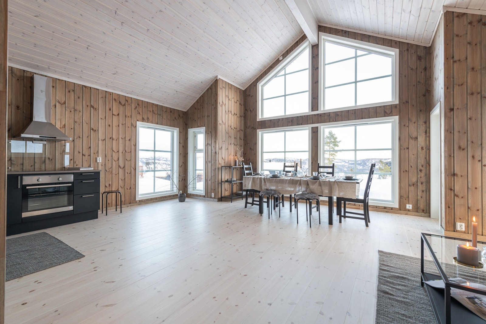 Luftig stue med høyt under taket og store vindusflater Galleribilde