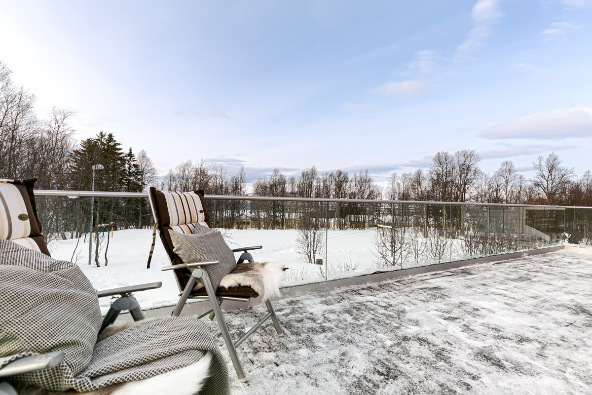 Stor terrasse på rundt 29 kvm og glassrekkverk som gir luft