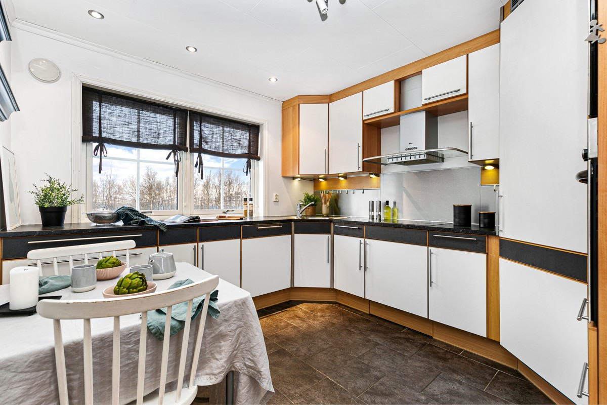 Kjøkken med rikelig med skapplass, vindu og rom for eget frokostbord