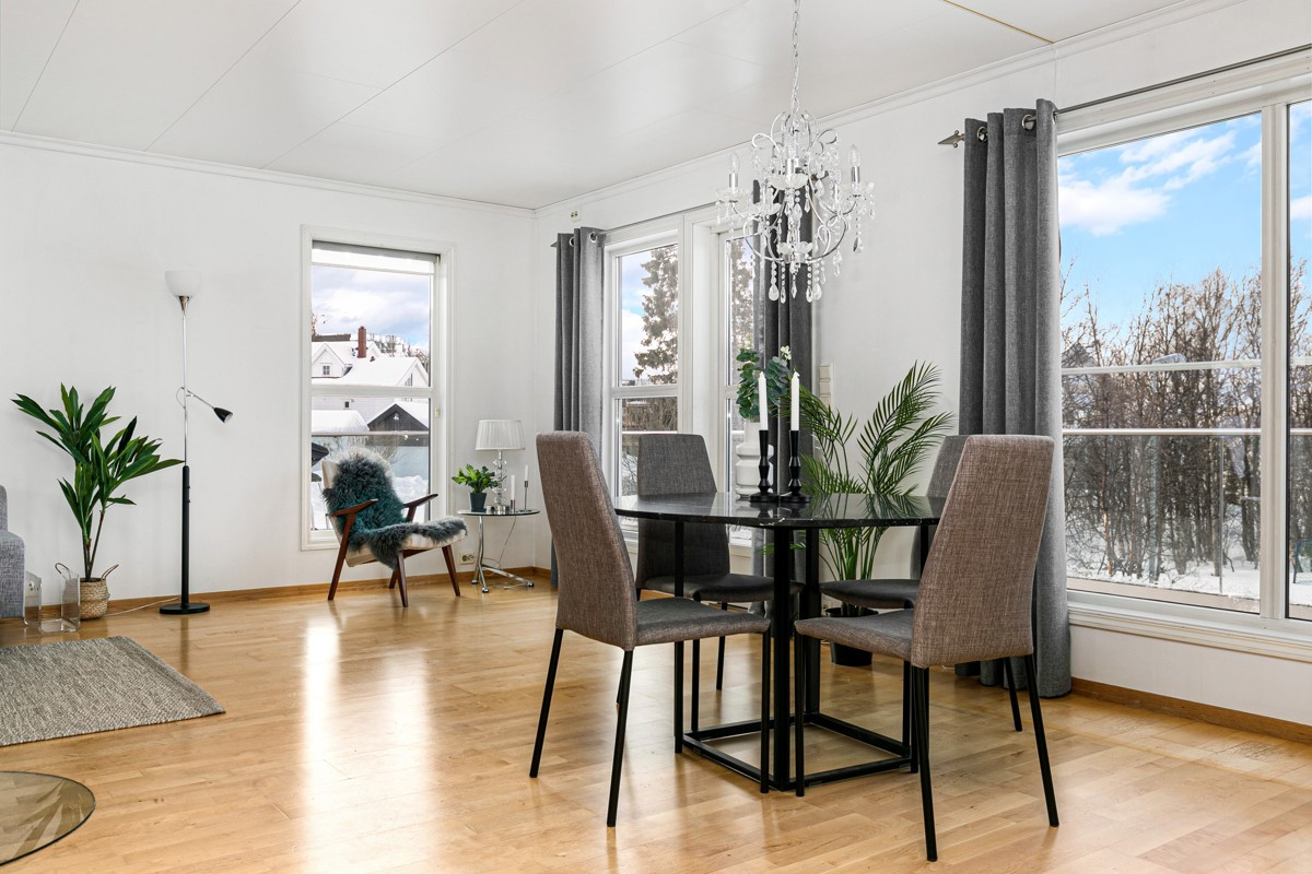 Parkett på gulv, store vinduer og vedovn er med på å gi en god atmosfære
