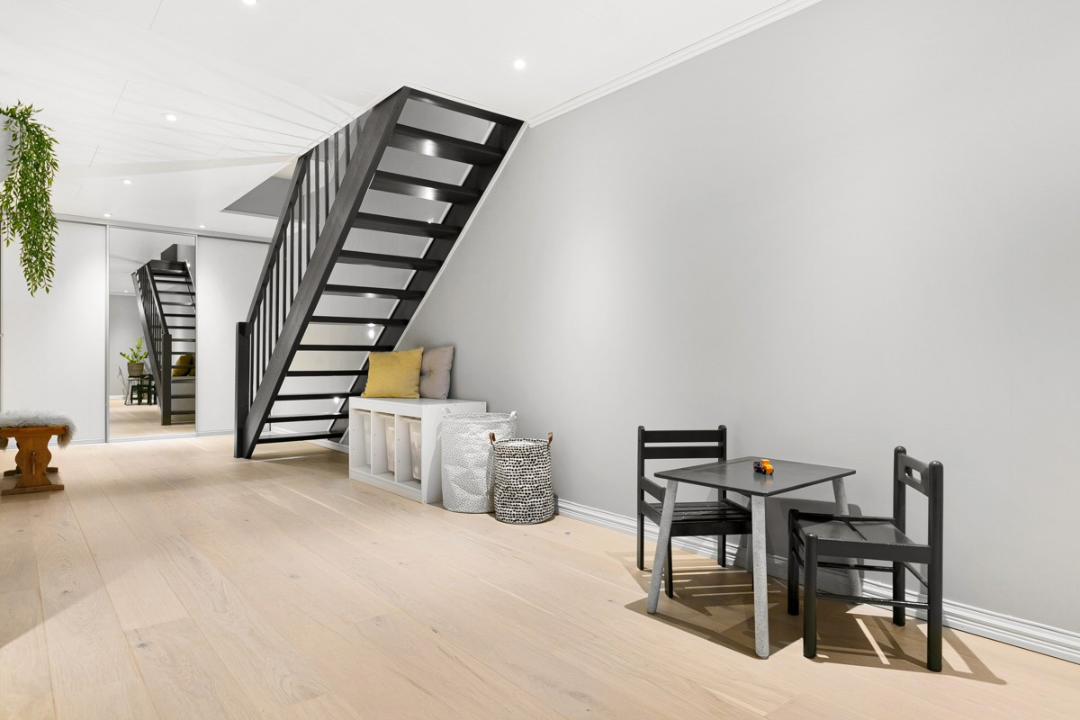 Trapp og gang i kjeller holder en moderne standard med stor skyvedørsgarderobe