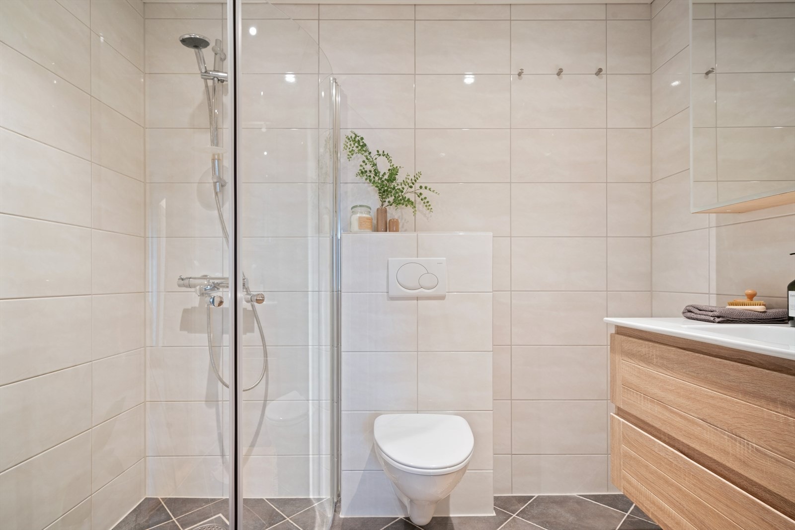 Badet er helfliset med fliser i tidløse farger og fremstår som moderne og innbydende. Galleribilde