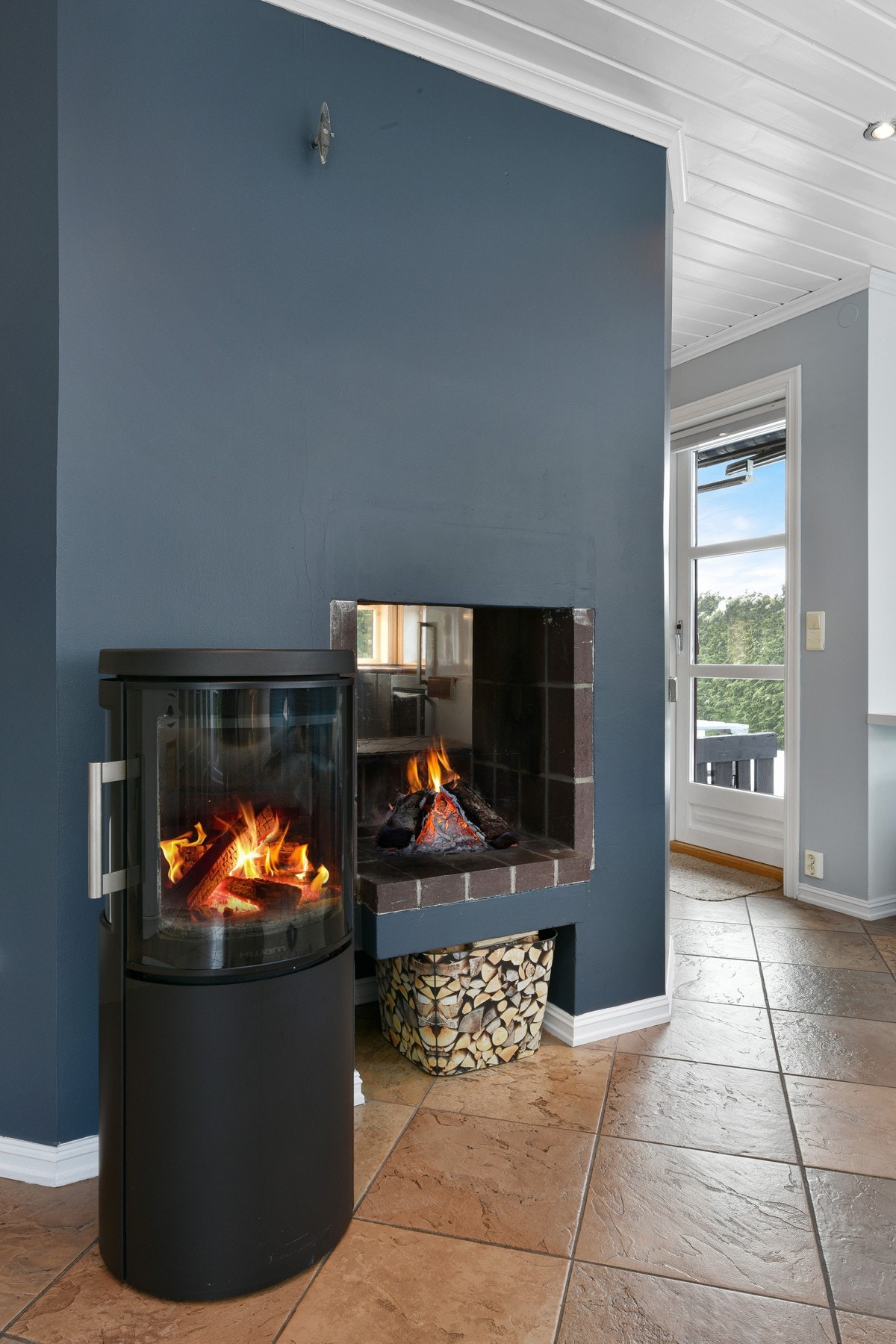 Stuen har åpen peisen og en ny, moderne peisovn. Sistnevnte er fra Hwam, fra 2019. Galleribilde